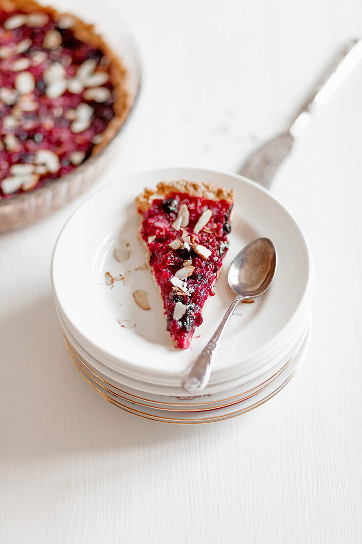 A slice of berry tart with flaked almonds