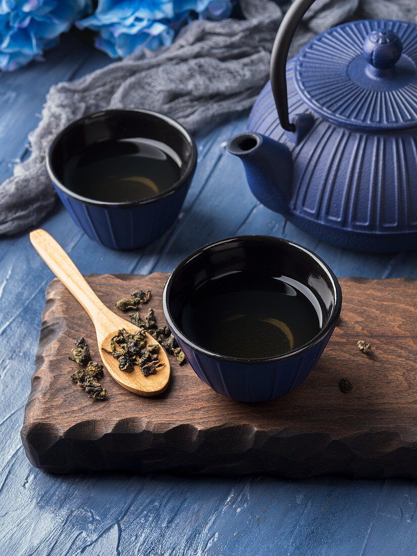 Green tea in blue cups with blue cast iron tea pot