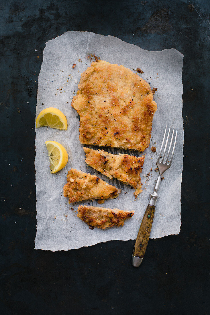 Classic Viennese veal escalope on grease-proof paper, sliced