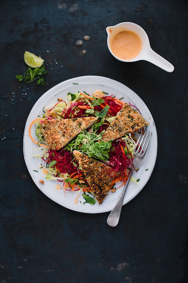 Turkey escalope with a nut crust with beetroot rice noodles, julienned carrots and a herb and cress salad