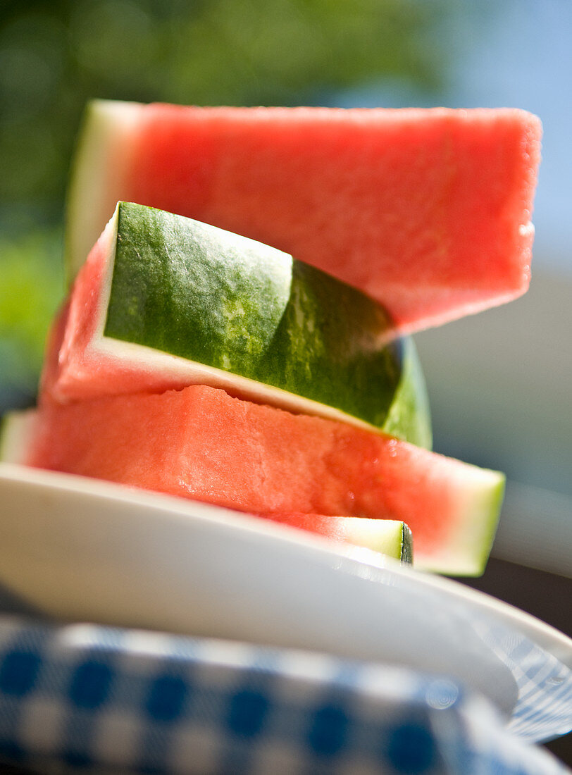 Watermelon pieces, stacked, on a plate