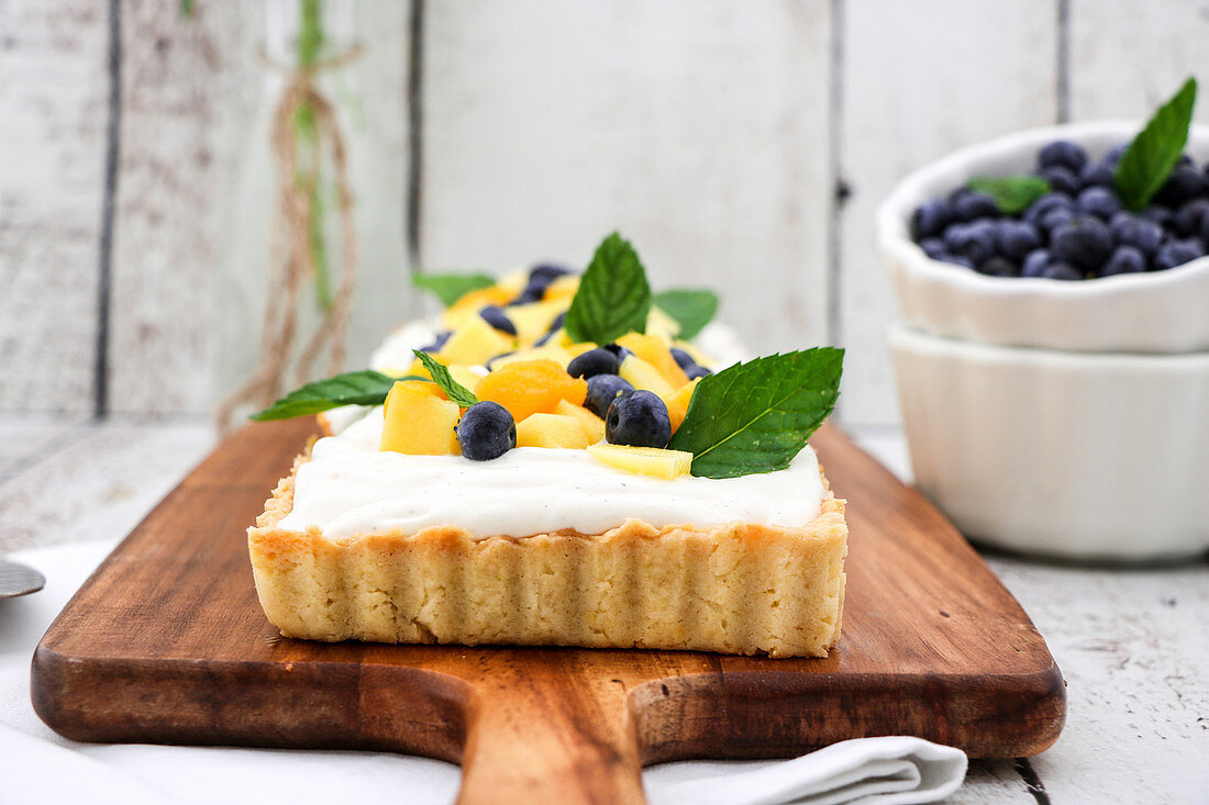 Yoghurt and coconut tart with mango, blueberries and mint