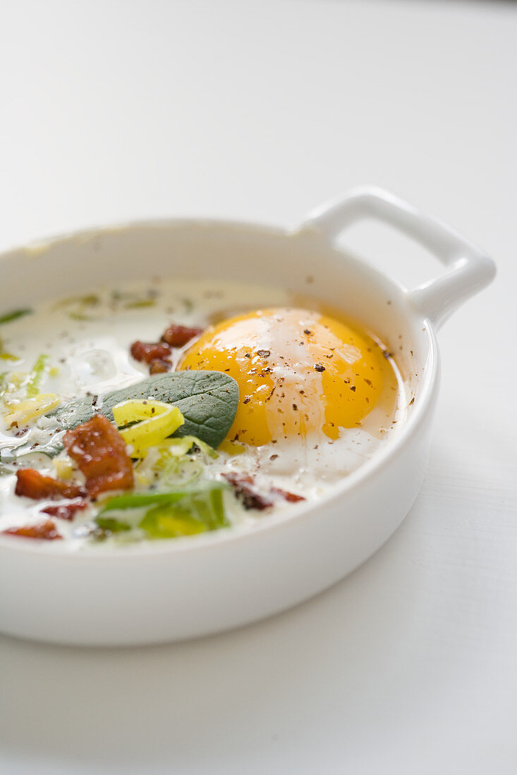 Baked egg with pancetta and onion cream in Ramakin