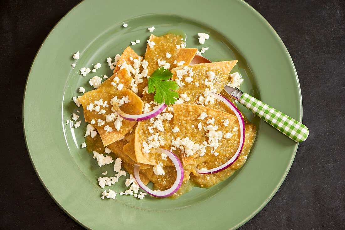 Chilaquiles (Frittierte Tortilla) mit Käse und roten Zwiebelringen (Mexiko)