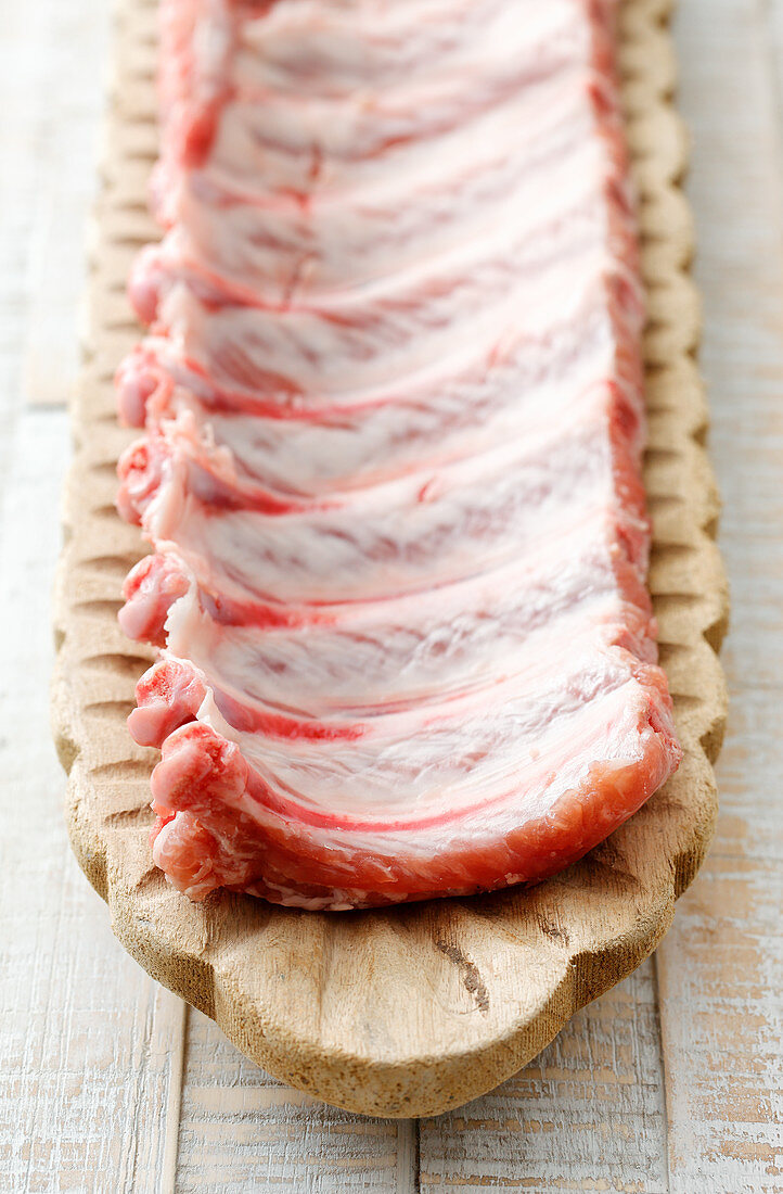 Raw pork ribs in a wooden dish