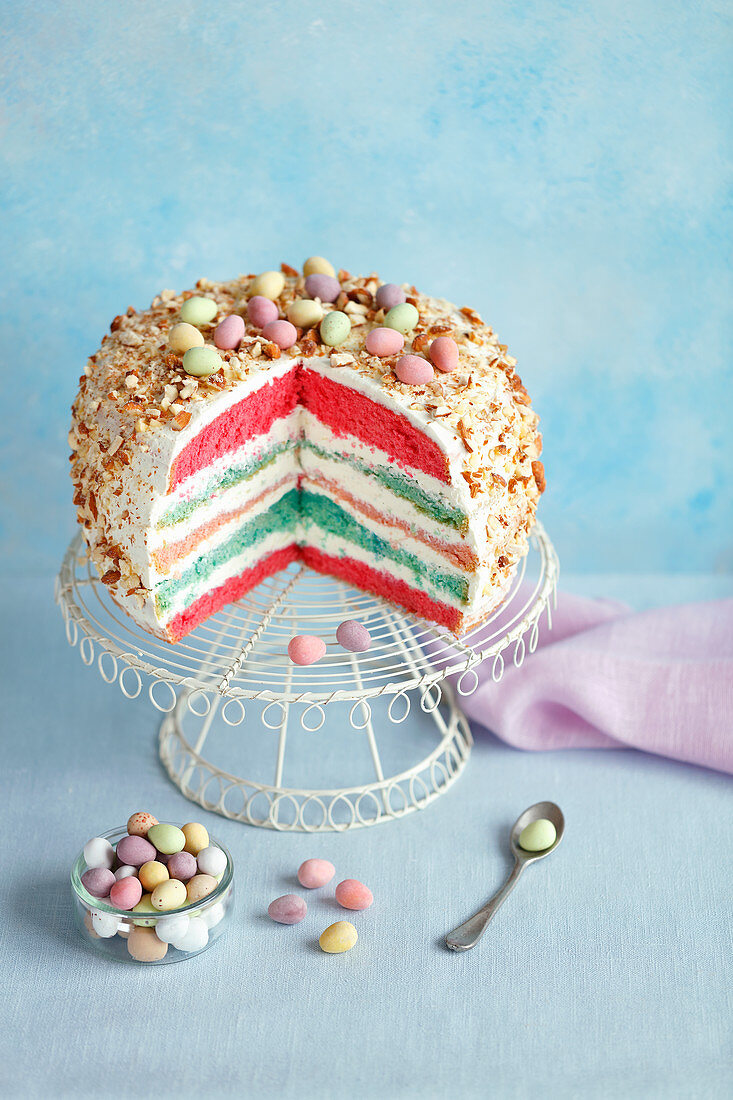 An Easter layer cake decorated with sugared eggs, sliced