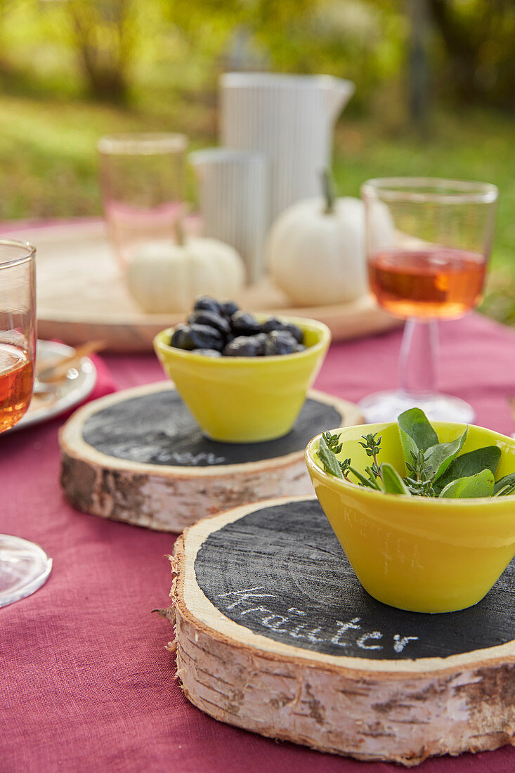 DIY coasters made from bark discs painted with black chalkboard paint as table decoration