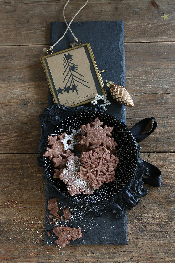 Gluten-free snowflake biscuits with cocoa and icing sugar for Christmas