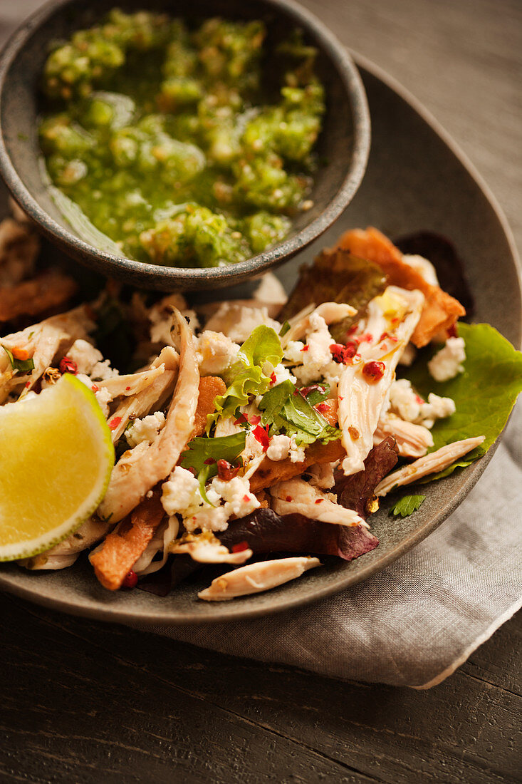 Chilaquiles with chicken served with tomatillo salsa (Mexico)