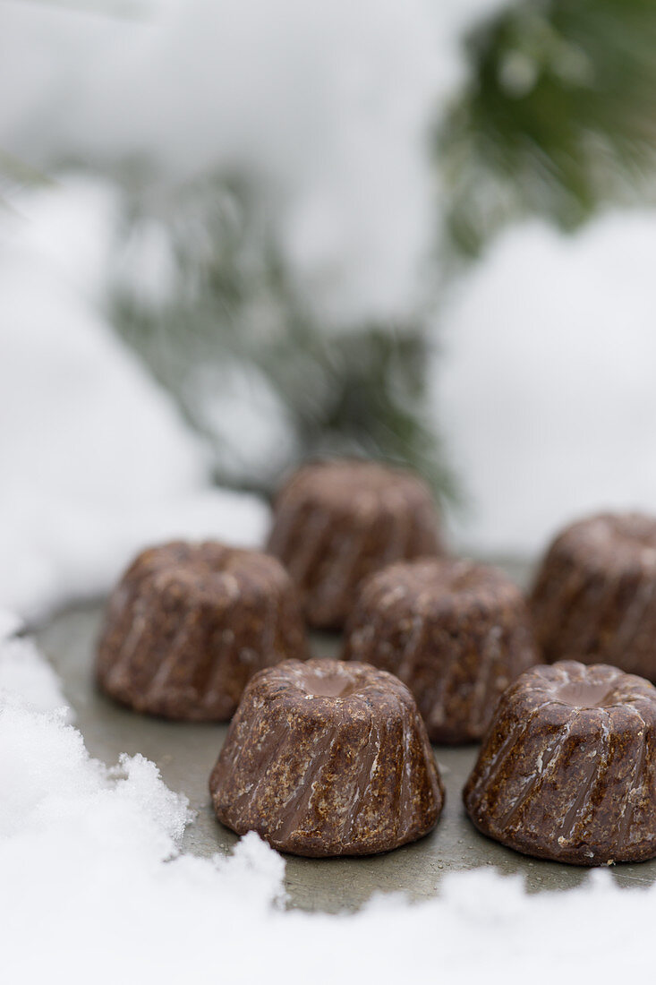 Mini Schokoladen-Guglhupf mit Schnapsglasur auf Tablett im Schnee