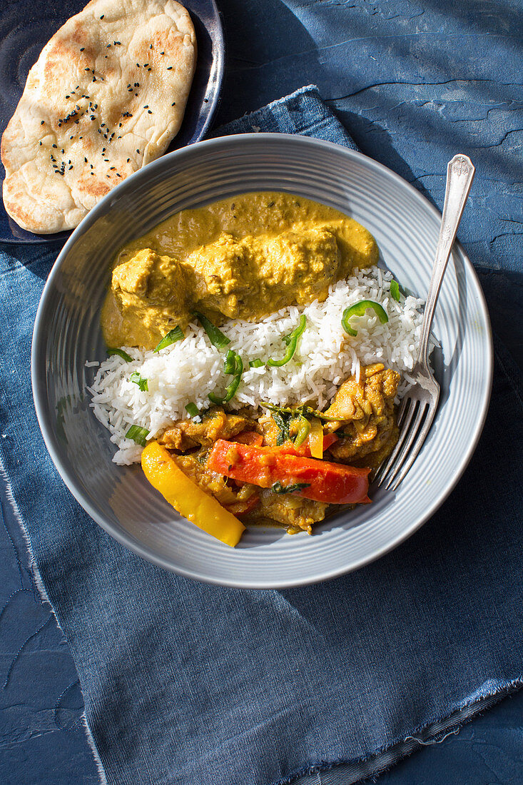 Chicken jalfrezi and chicken korma with rice and naan bread (India)