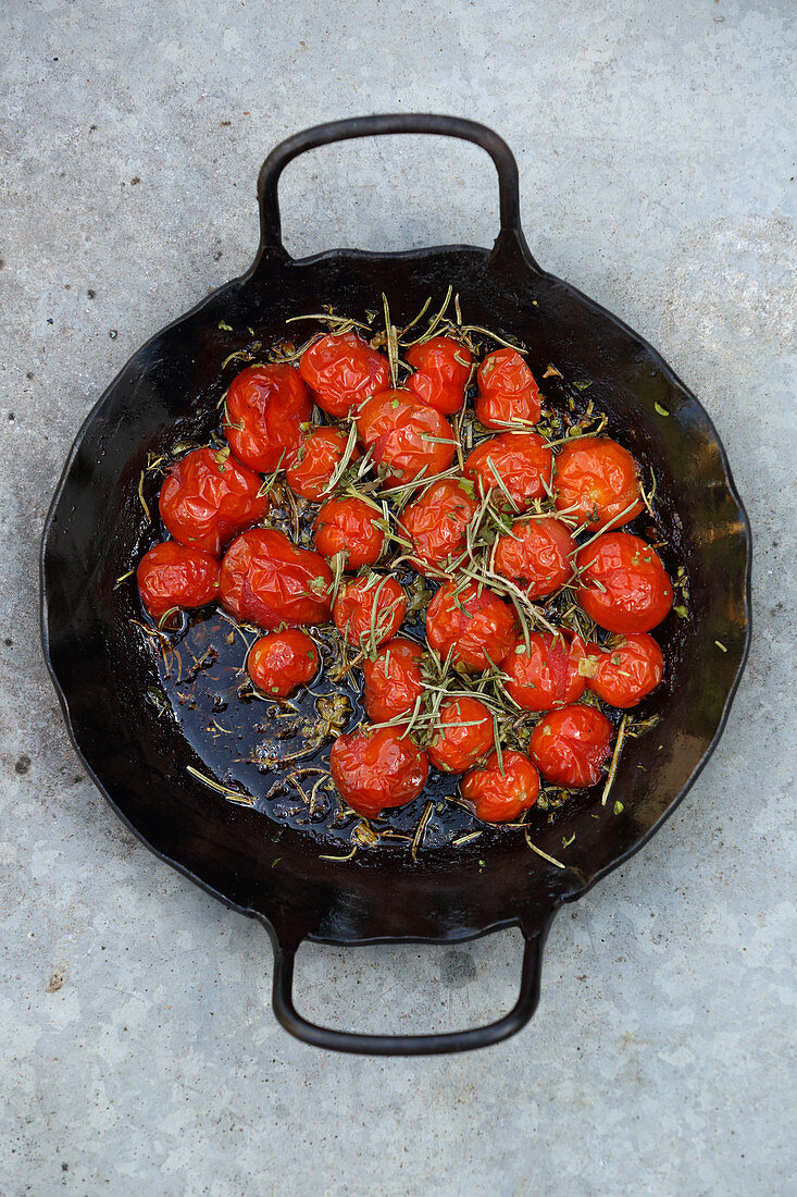 Grilled cherry tomatoes in an iron pan