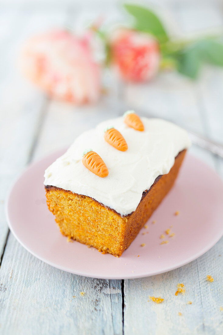 A mini carrot cake topped with cream cheese frosting and marzipan currents