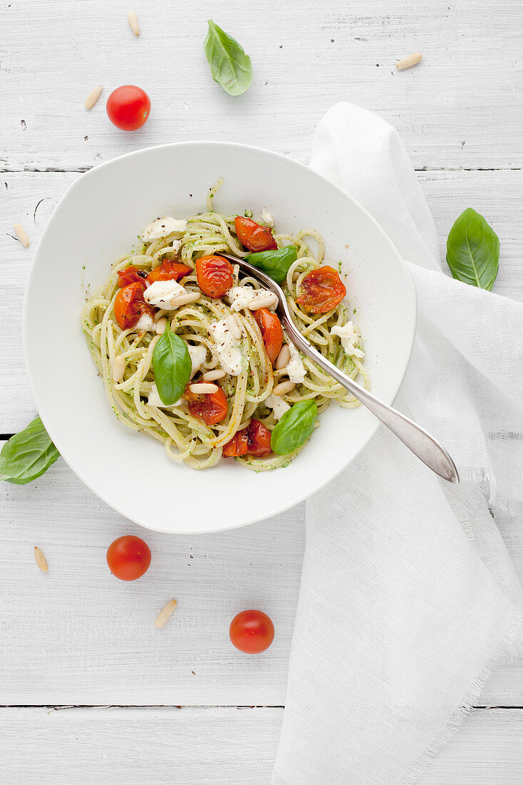 Pasta with tomatoes, mozzarella, pine nuts and basil