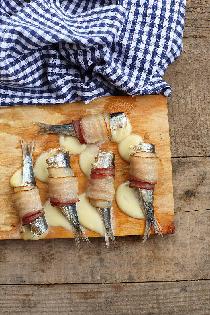 Stuffed herrings wrapped in bacon on a grill