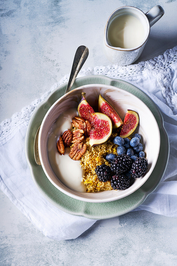 Breakfast Bowl mit Quinoa, Sojajoghurt, Früchten und Pecannüssen