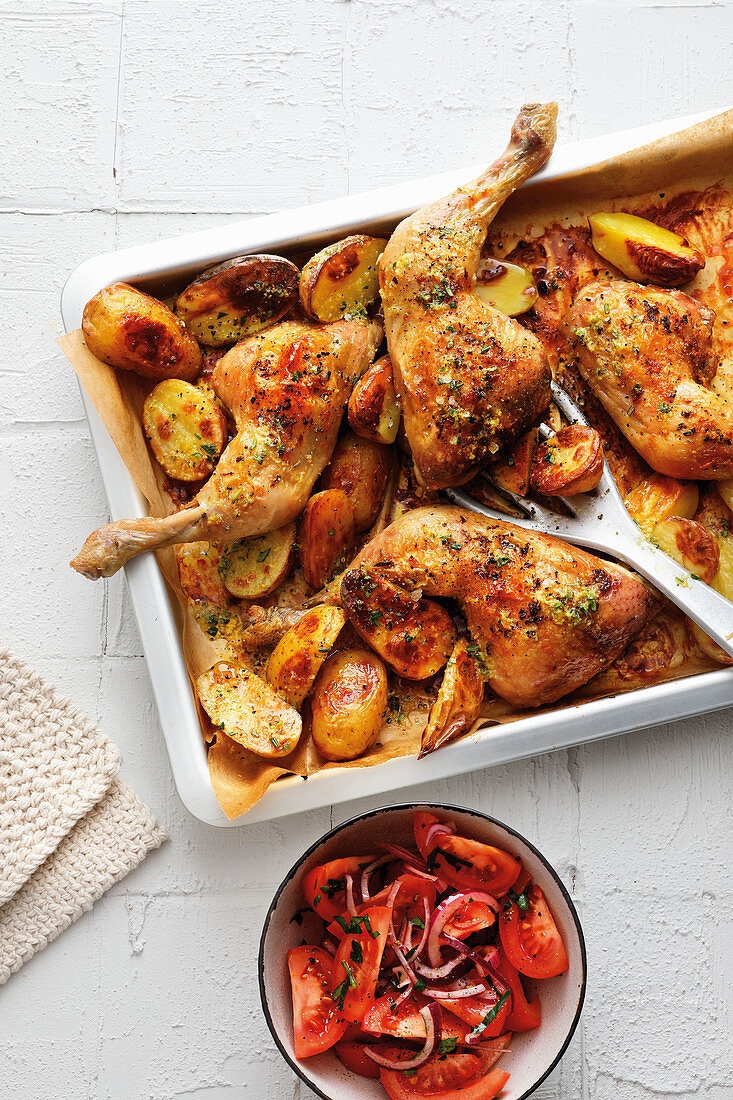 Chicken drumsticks with baked potatoes on a tray