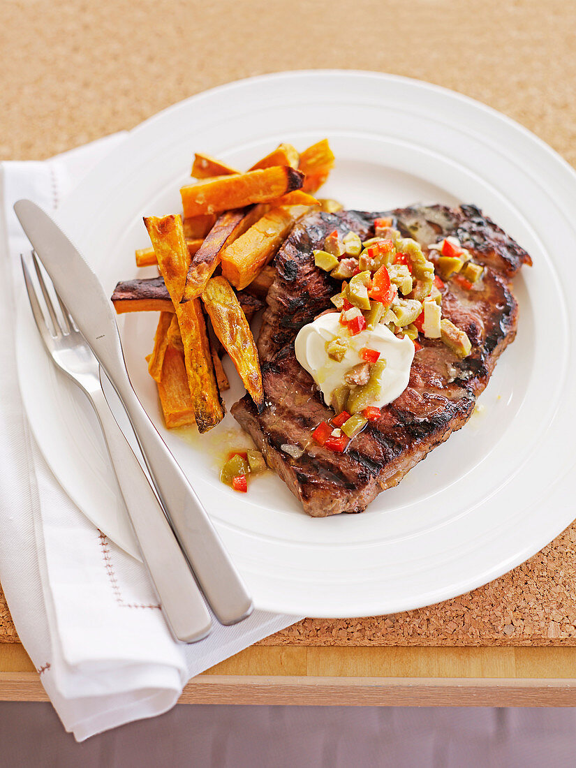 Steak with baked kumara chips and olive salsa