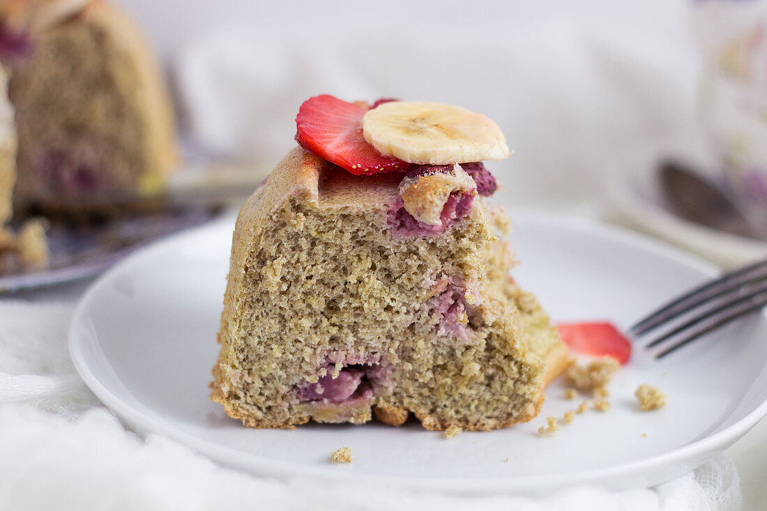 Ein Stück Eiweiss-Haferkuchen in Kranzform mit Bananen und Erdbeeren