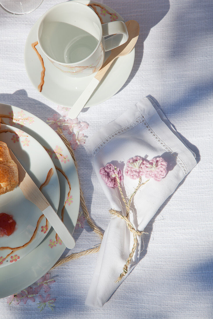 Vintage-style place setting with hand-painted crockery and crocheted flowers