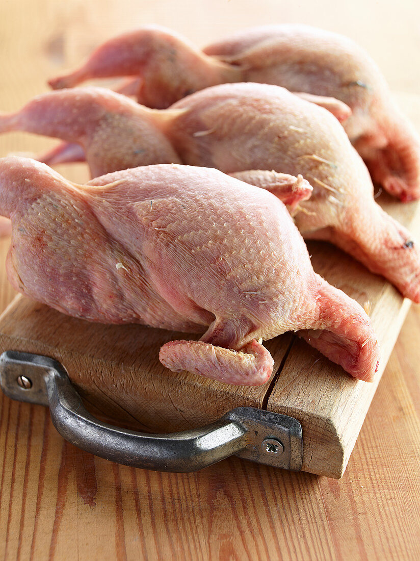 Fresh quails on a wooden board