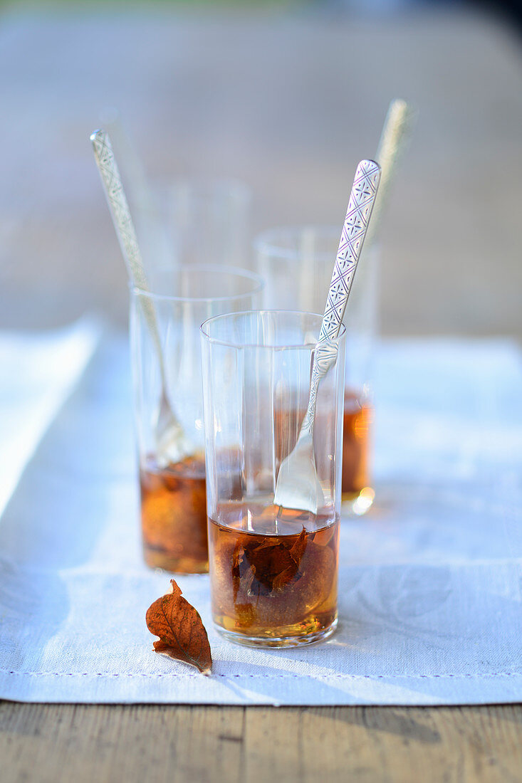 Mispeln in Cognac serviert in Gläsern mit Gabeln