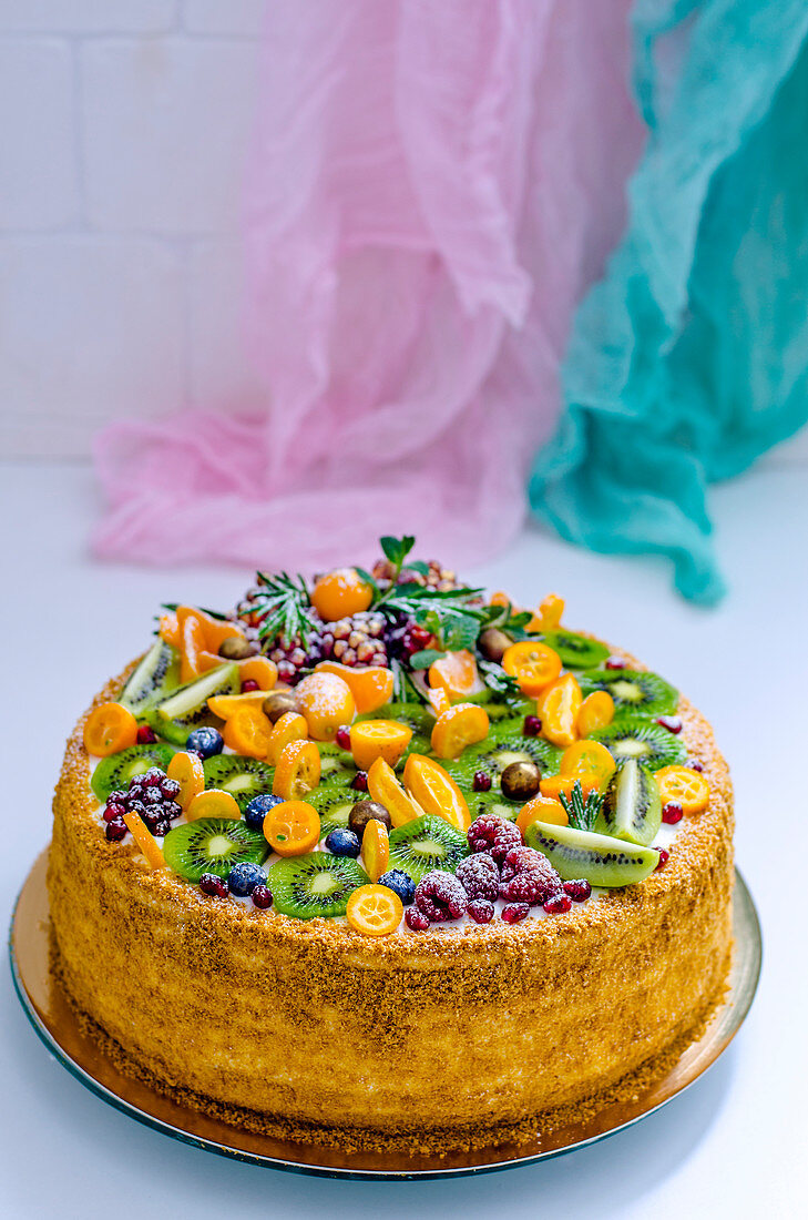 A festive fruit cake with kiwis and kumquats