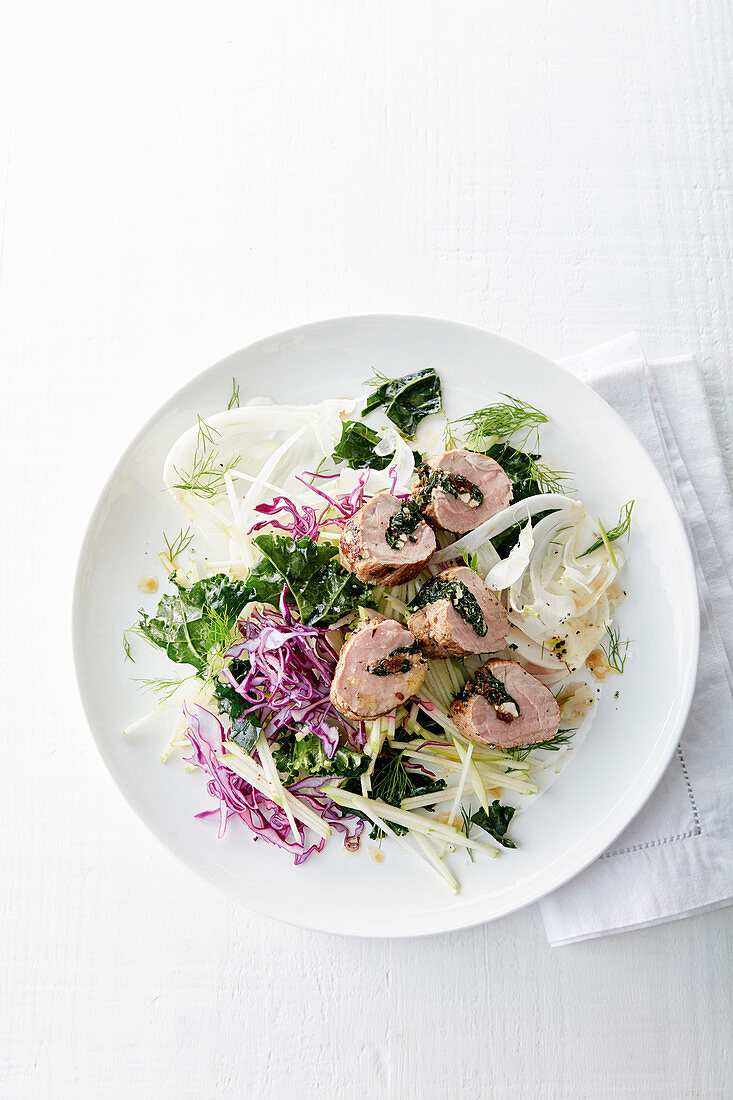 Stuffed pork tenderloin with kale and garlic on coleslaw