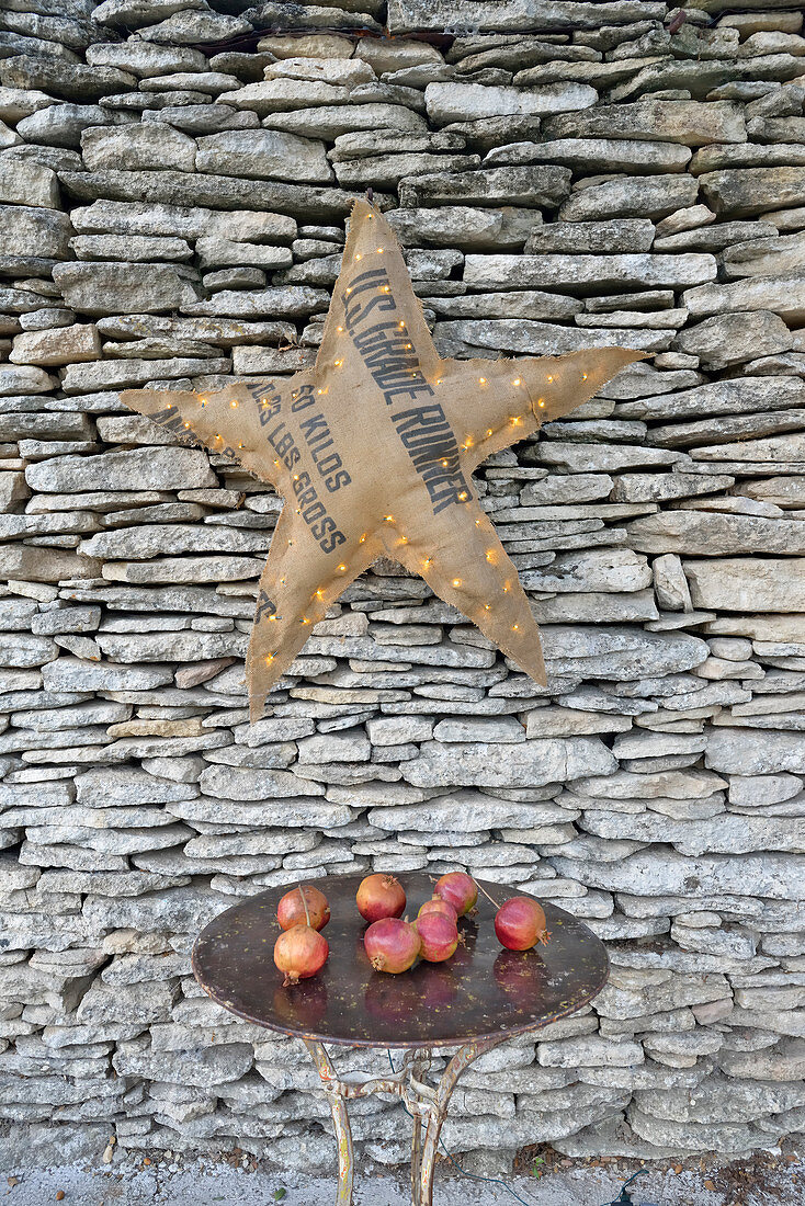 Illuminated star made from hessian sack on stone wall