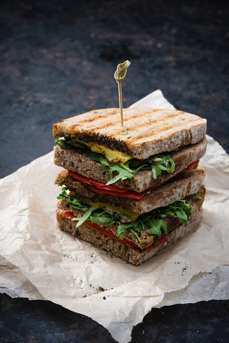 A vegan sandwich with grilled peppers, rocket and cheese substitute