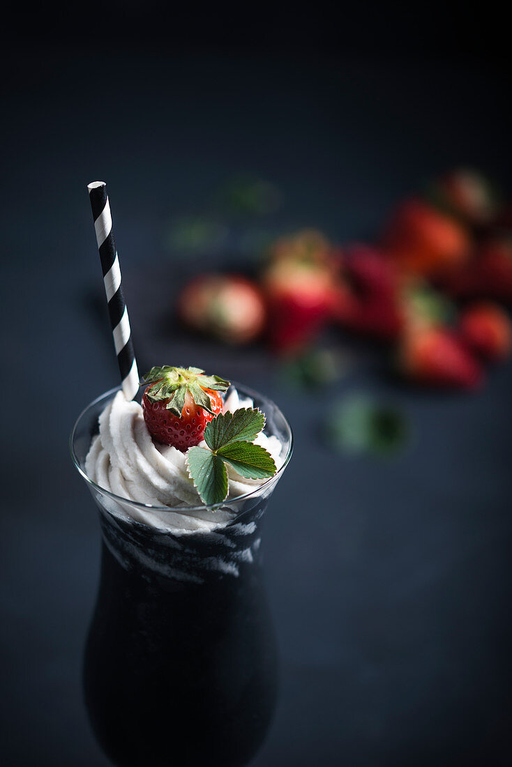 A black vegan shake with a coconut and marzipan topping