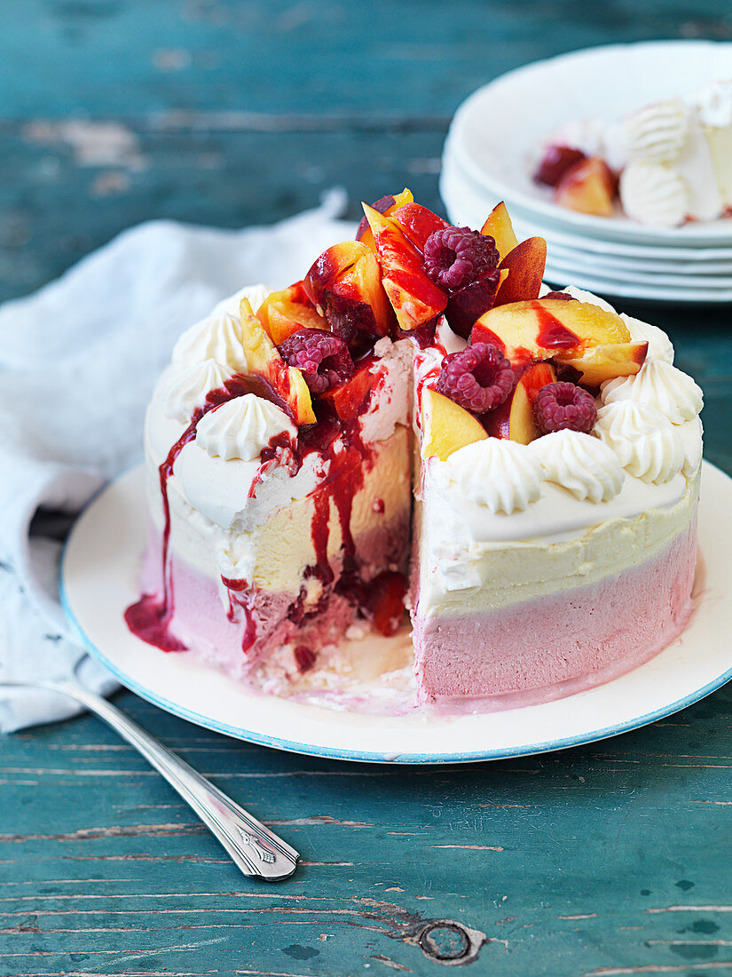 Pfirsich-Melba-Eiskuchen mit Himbeeren, angeschnitten