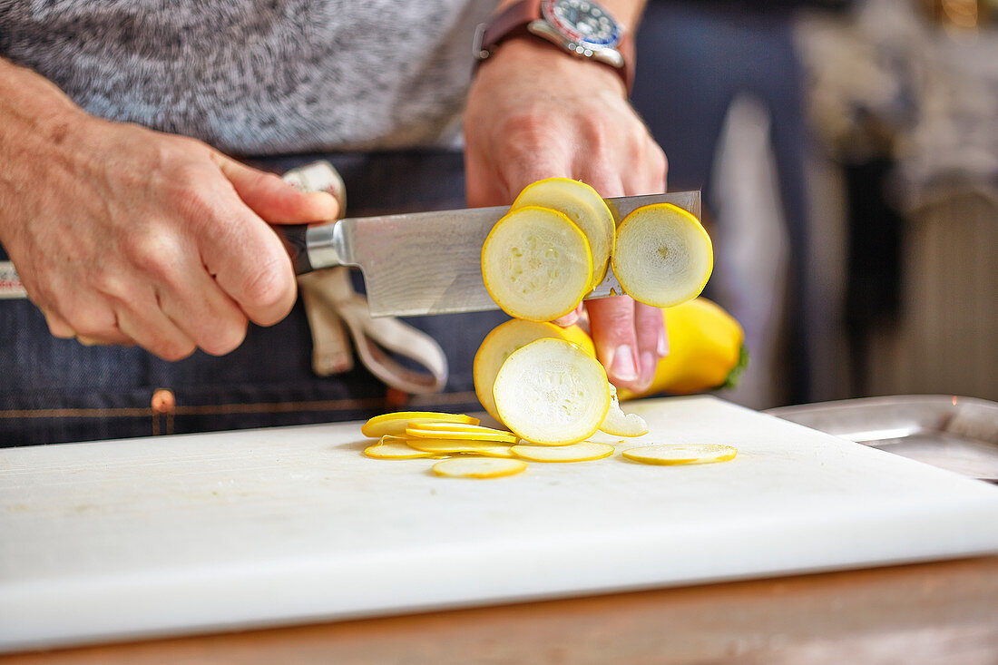 Gelbe Zucchini in feine Scheiben schneiden