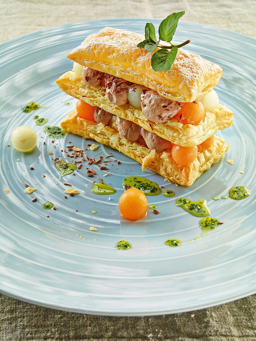 Melon puff pastry tower with chocolate mousse and mint oil