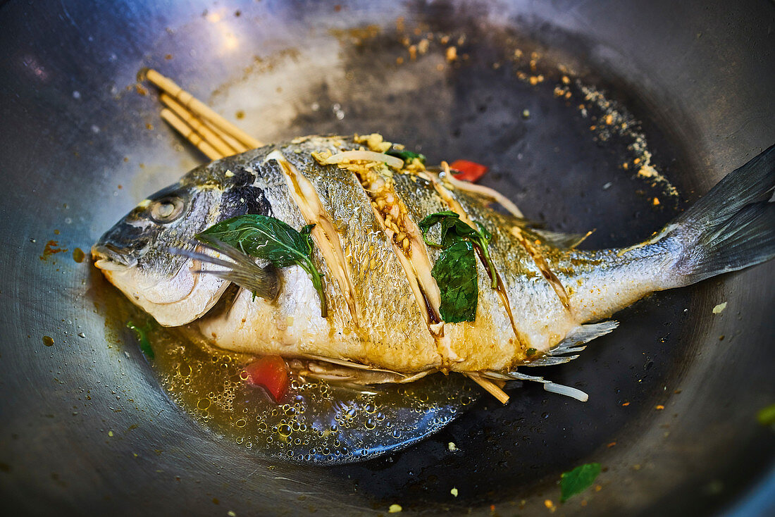 Fisch mit asiatischen Gewürzen im Wok braten