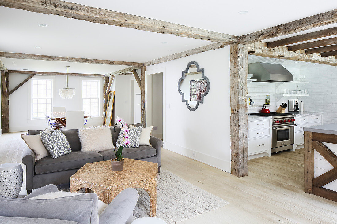 Rustic wooden beams in open-plan interior with view into kitchen