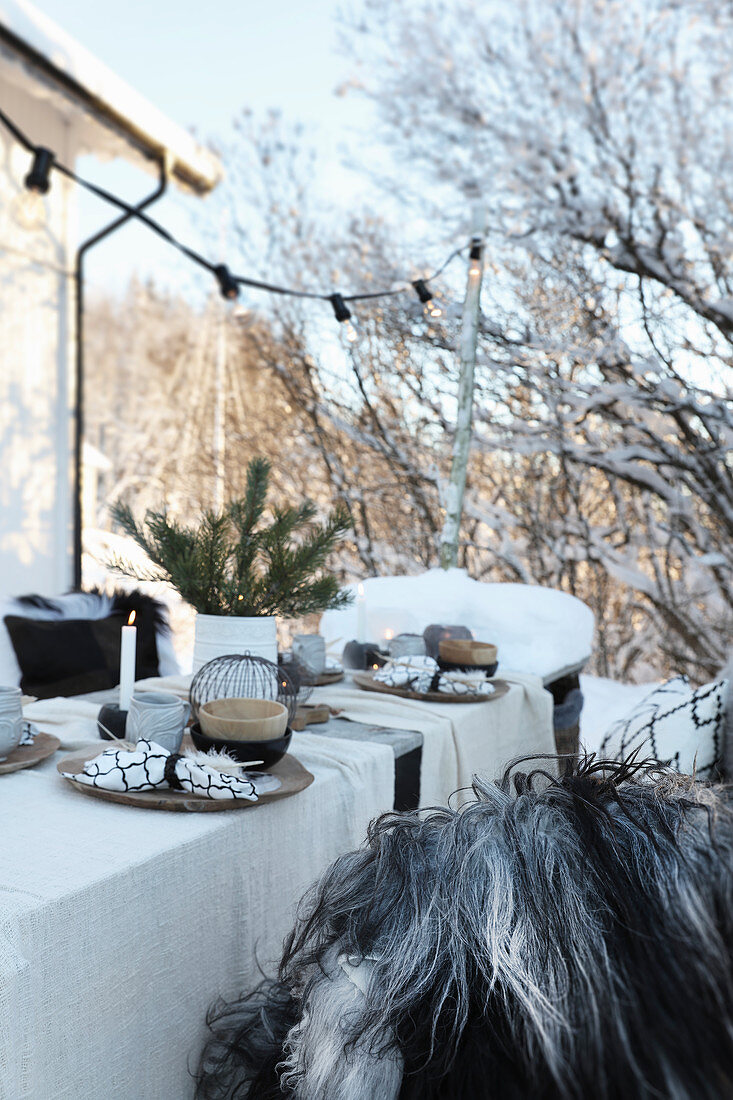 Gedeckter Tisch mit Weihnachtsdekoration im Garten