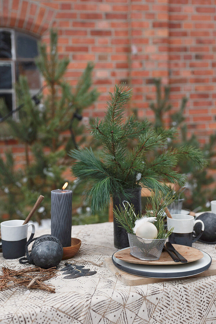 Table set for Christmas with fir branches and black candles