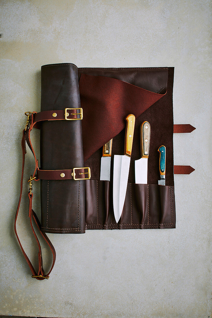 Handmade pocket knives in a rollable leather case of the brand 'Maka