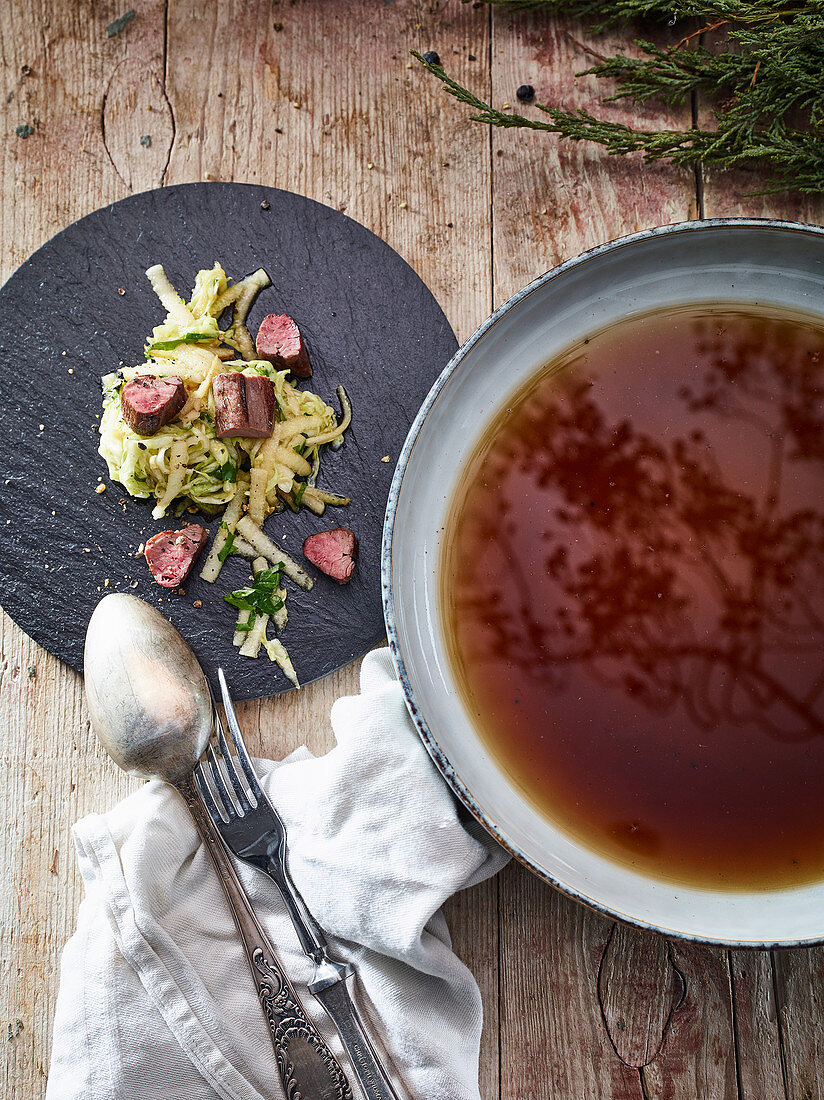 Venison fillets with cabbage salad and clear mushroom soup