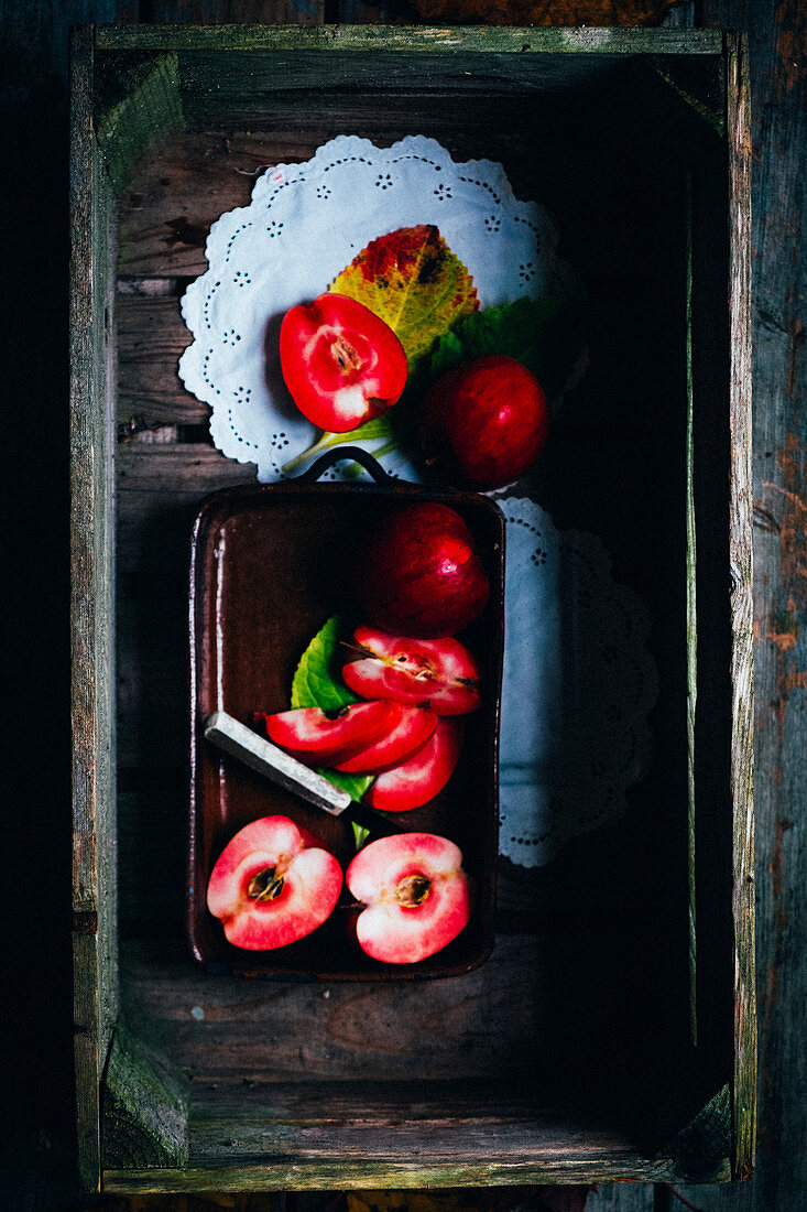 an arrangement of red apples in a dish on a lace doily (seen from above)