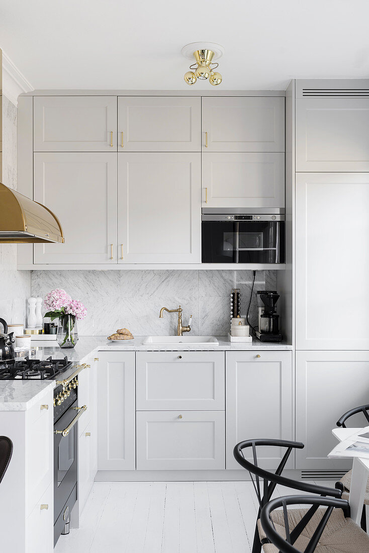 Pale grey fitted kitchen with marble splashback