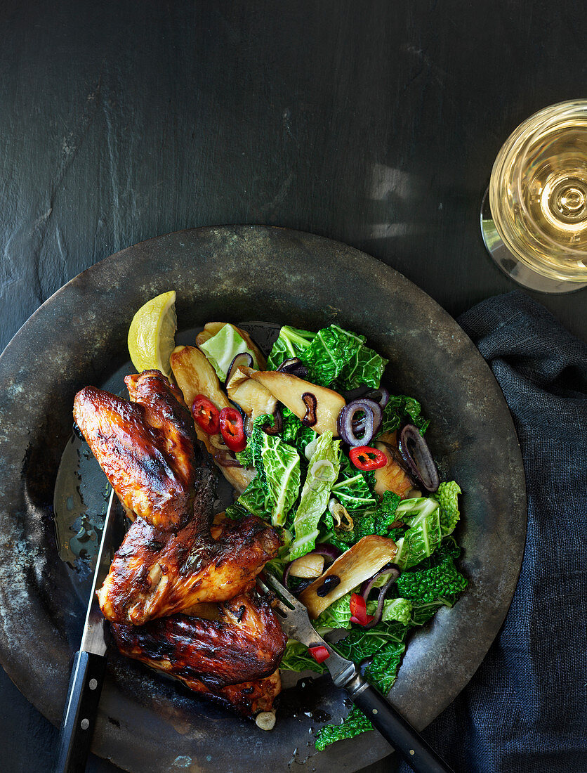 Caribbean marinated grilled chicken wings with savoy cabbage and mushrooms