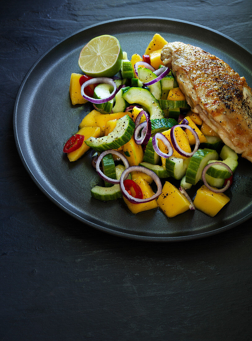 Grilled chicken breast with a cucumber and mango salad