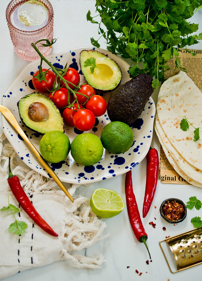 Tortillas, avocado, tomatoes, limes, spices and coriander leaves