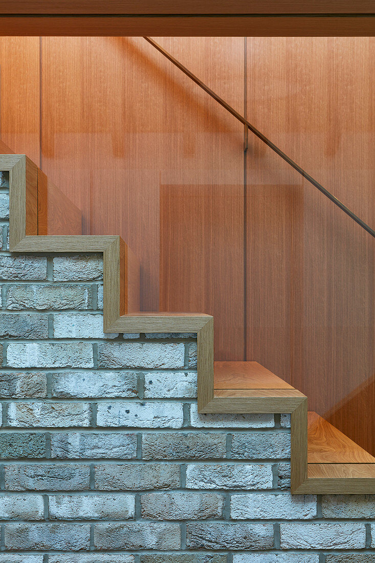 Wooden treads on brick staircase with glass balustrade