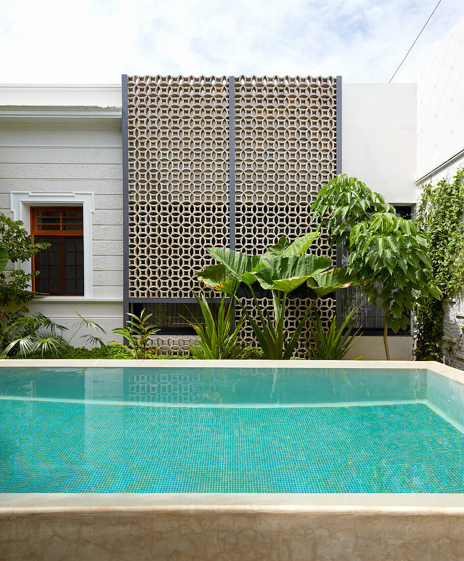 Pool in exotic courtyard with wall of ornamental perforated bricks