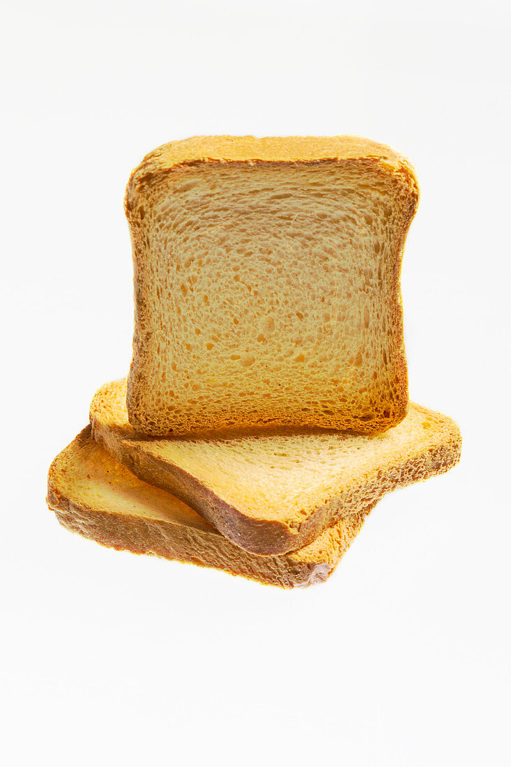 Three slices of zwieback (rusk) on white background