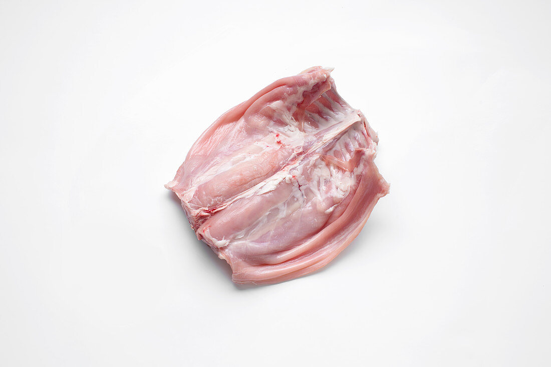 A whole saddle of rabbit on a white surface