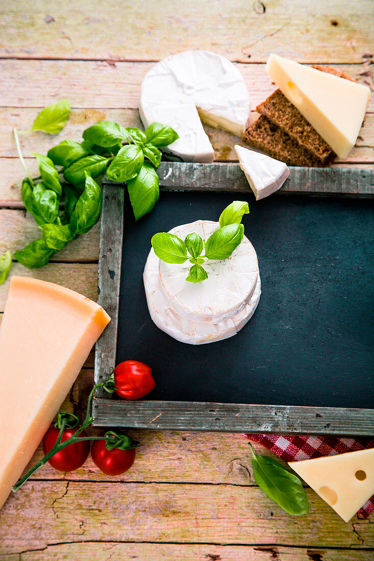 Italienische Küche: Stillleben mit Käsesorten, Tomaten und Basilikum